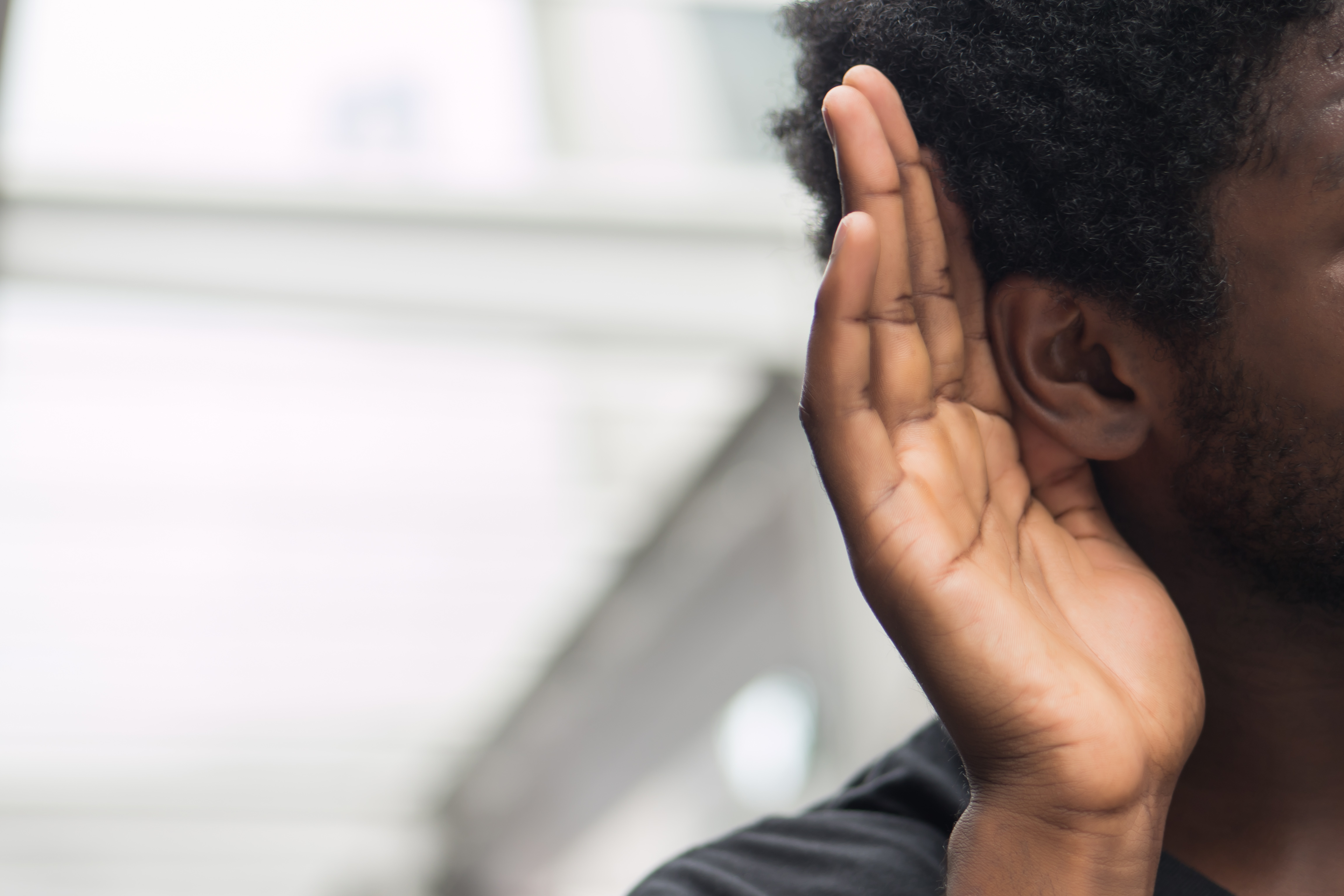 A man putting his ear out to listen